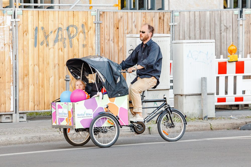 father cycling through Berlin with his baby